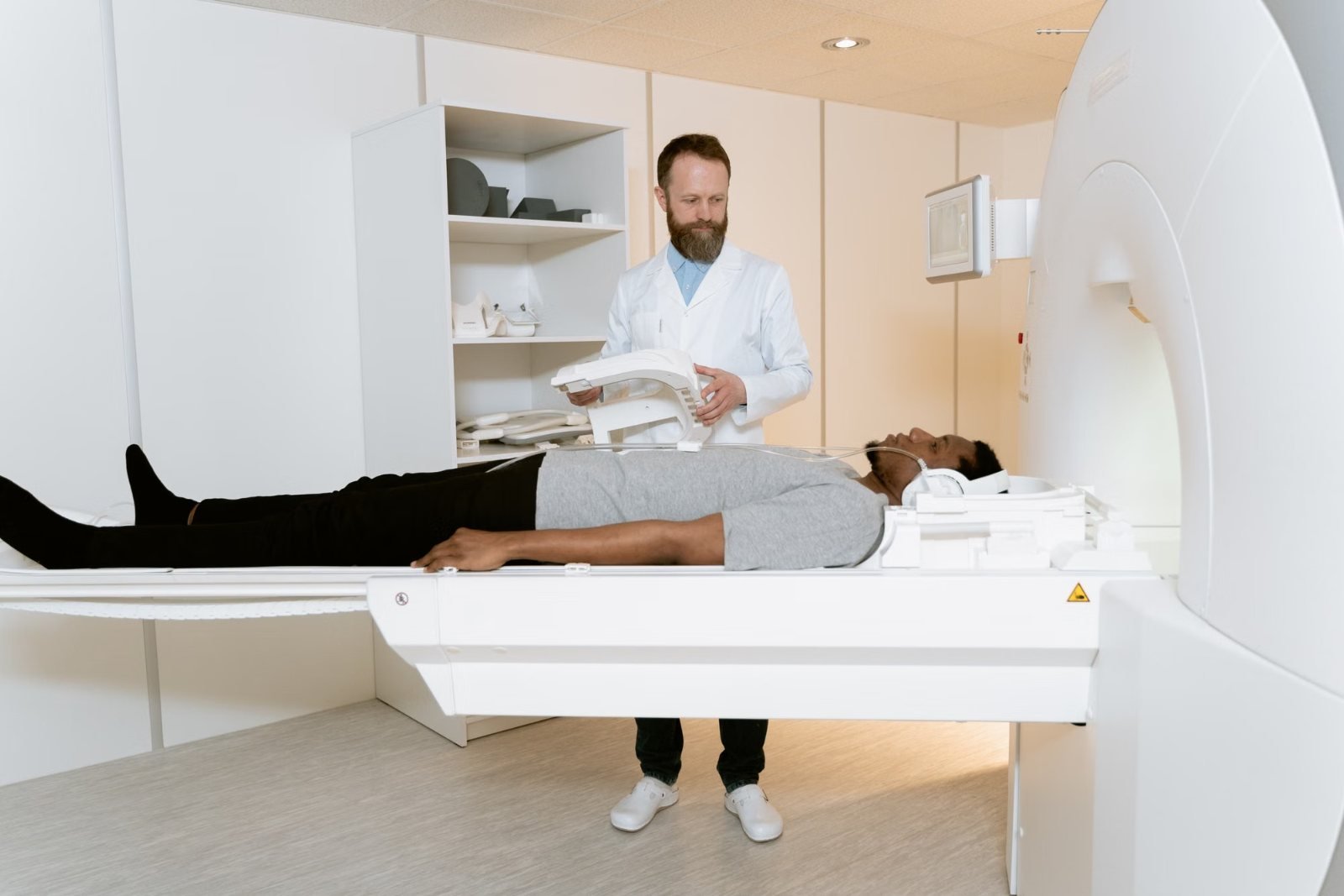 A patient lying on a scanner table beside a radiographer