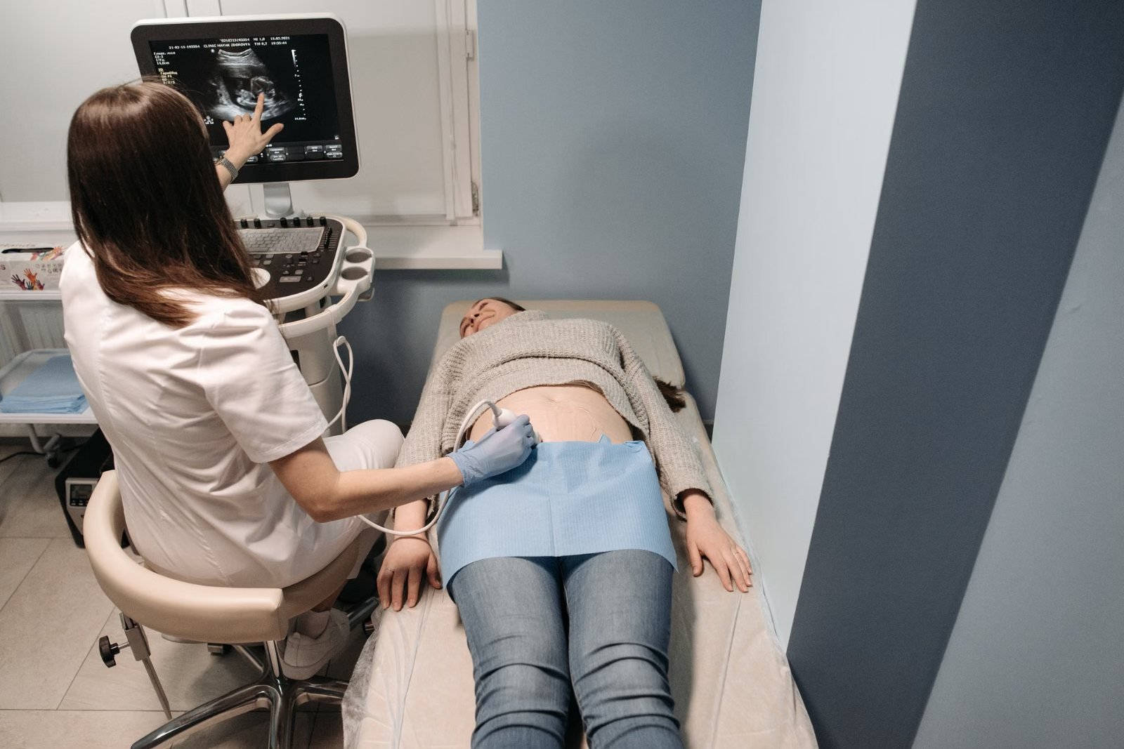 A sonographer scanning a patient's abdomen