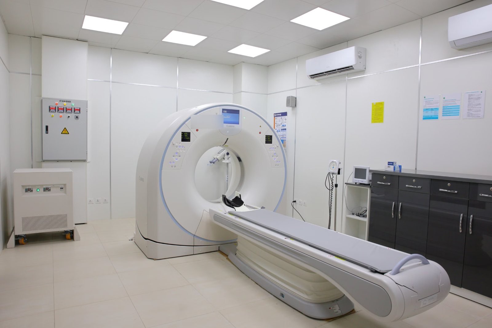An empty CT scanner room with the table extended, seen from the side