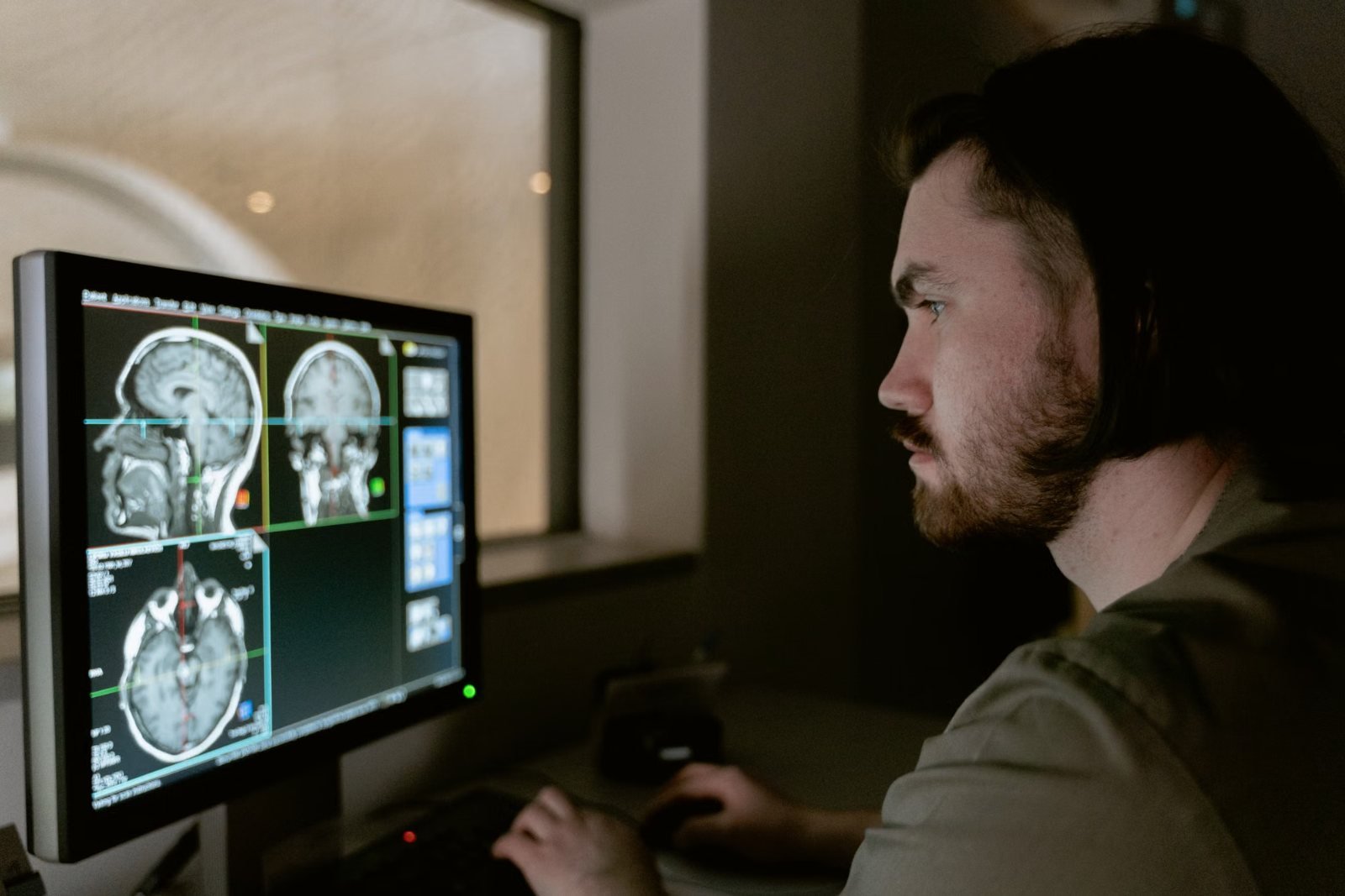 A man looking at brain MRI images on a monitor