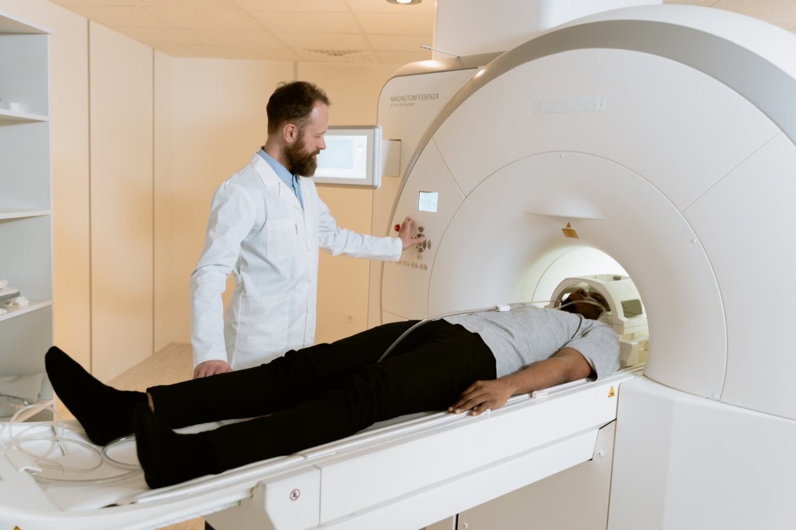 A radiographer preparing a patient on an MRI scanner table