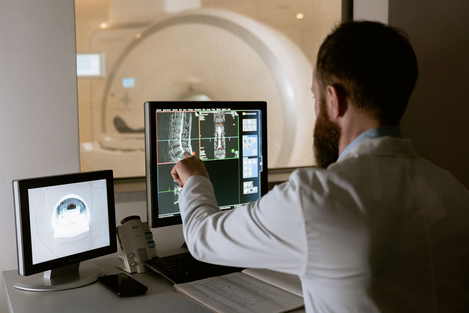 A clinician reading scan images on screen