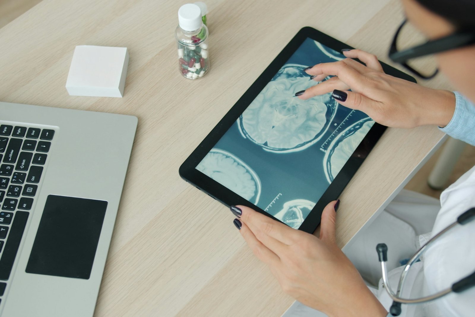 A clinician reviewing scan images on a tablet at a desk