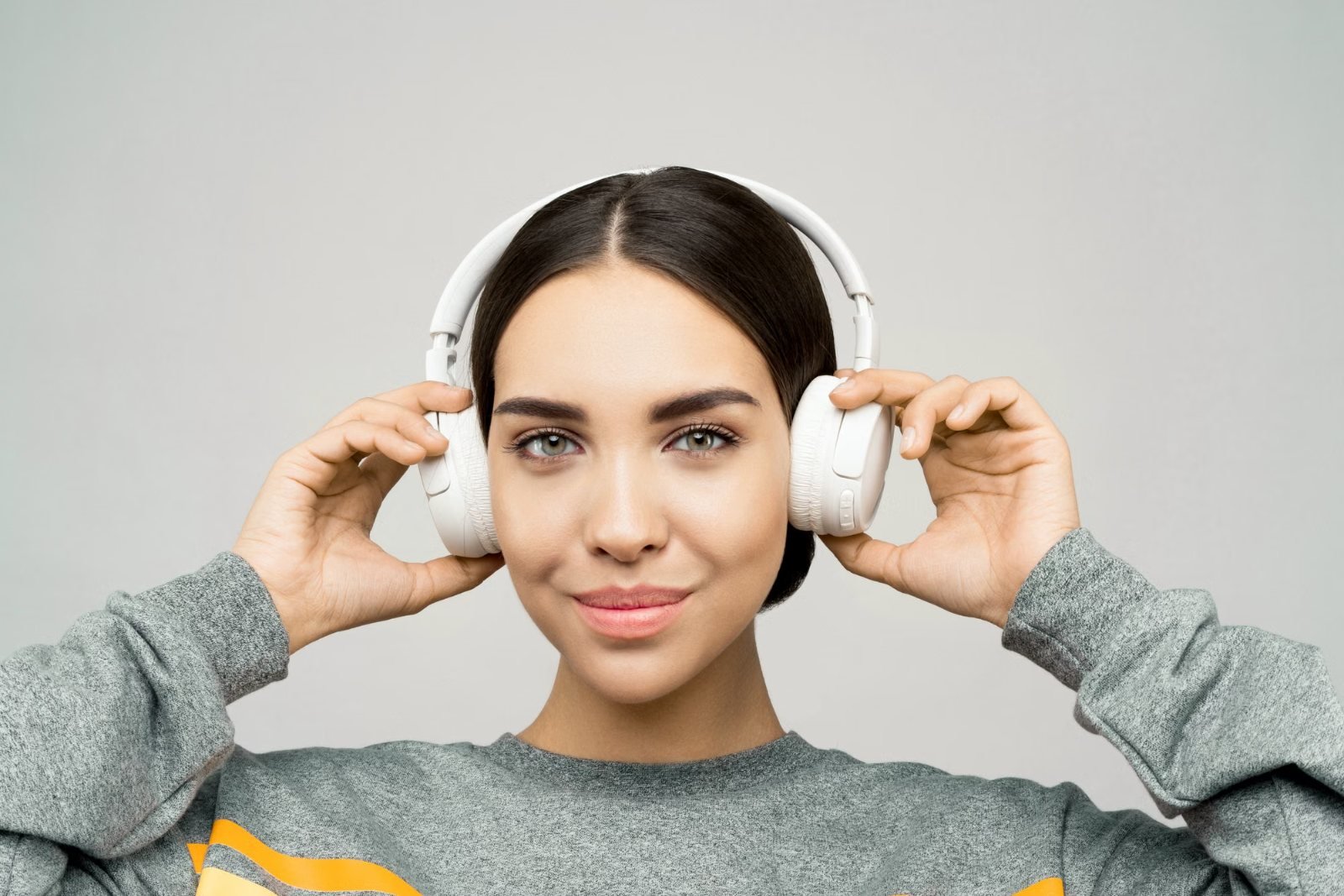 A woman putting on a pair of headphones