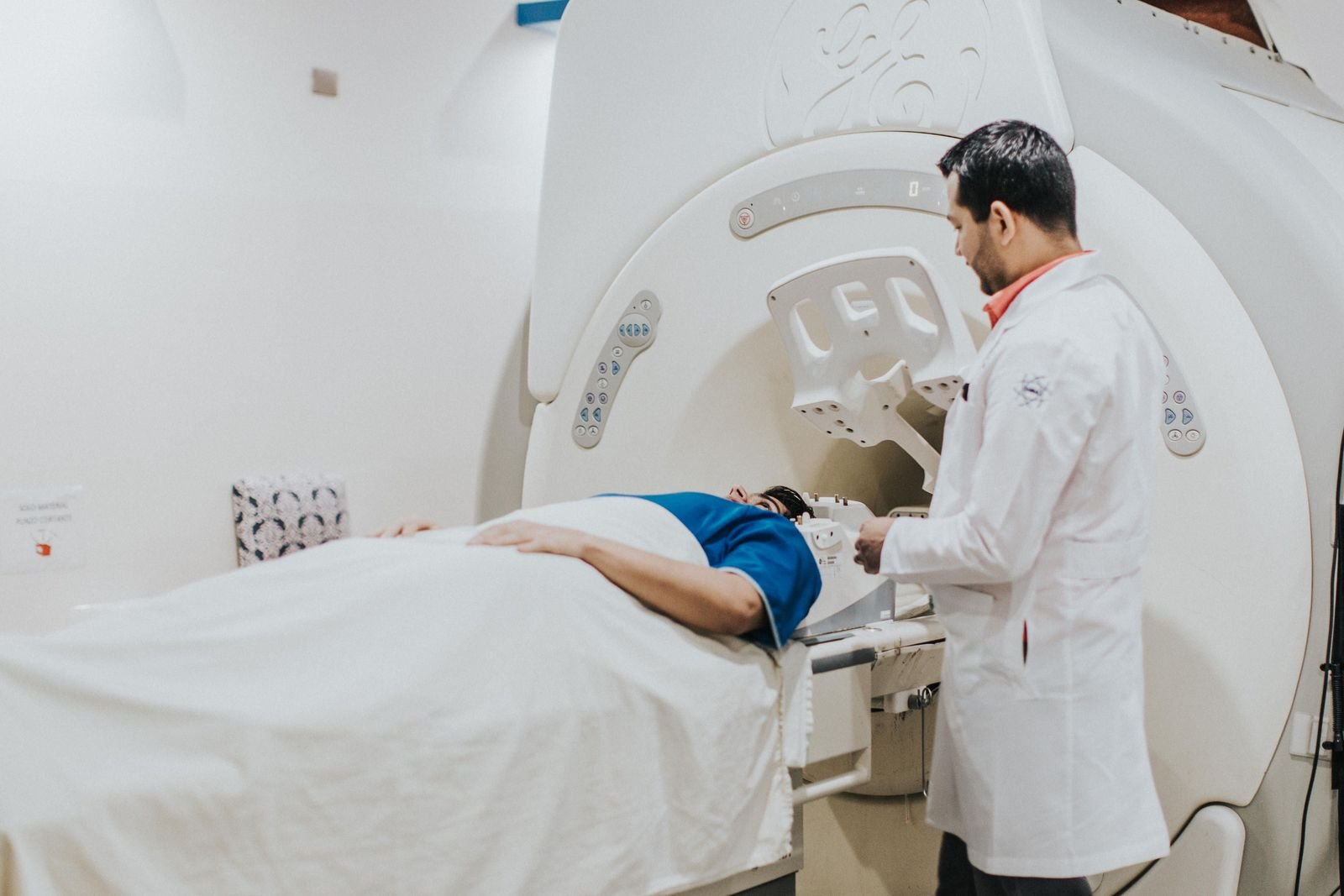 A doctor preparing a patient for a head MRI scan