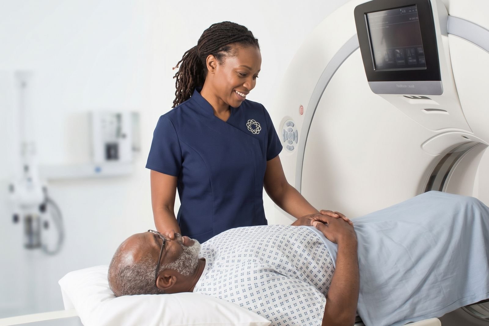 A radiographer reassuring a patient on a scanner table